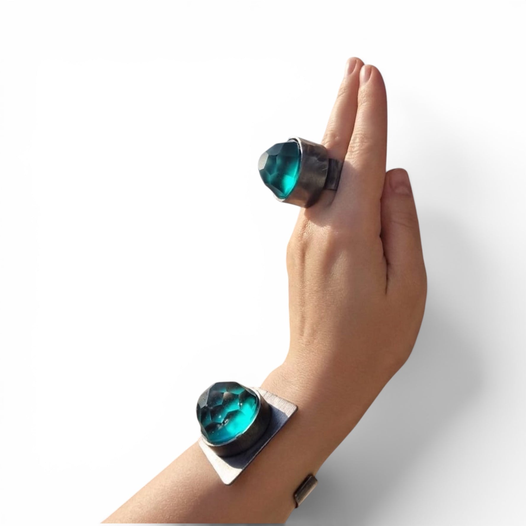 Selce Murano glass ring and cuff bracelet worn together — teal faceted glass set in wrought iron, white background